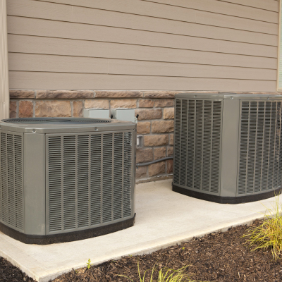 two hvac units side by side on a cement pad