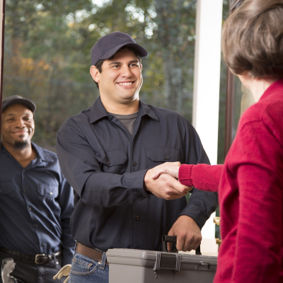 man shaking a woman's hand at the door